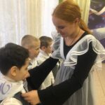 Девочка завязывает галстук